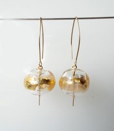 Give some subtle glitz to your look. This Statement Gold Glass Dangle earrings made of clear glass hollow beads decorated with bits of 24 karat gold leaf, Hanging on gold-filled hooks. These Clear blown elegant beaded earrings, add a touch of golden sparkle to your outfit. Whether you pair them with your favorite sundress or jeans and a blouse, you’re going to love these Clear glass earrings!Features:~ Handmade~ Made to order~ Materials: glass, gold-filled hooks, 24 karat gold leaf~ Lampwork bea Gold Czech Glass Beaded Earrings For Party, Gold Czech Glass Earrings For Party, Party Gold Earrings With Czech Glass, Elegant Czech Glass Pierced Earrings, Elegant Pierced Earrings With Czech Glass, Elegant Round Beaded Earrings For Celebration, Gold Beaded Glass Earrings, Gold Glass Earrings With Dangling Beads, Elegant Gold Beaded Earrings With Czech Glass