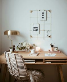 a desk with a chair, lamp and pictures on the wall in front of it