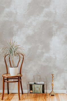 an empty room with a chair, plant and radio on the floor in front of it