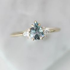 We love this timeless light blue sapphire ring with diamond accents in a yellow gold setting made by Gem Breakfast Unique Gemstone Engagement Rings, Sapphire Cluster Ring, Light Blue Sapphire, Montana Sapphire Ring, Blue Engagement Ring, Blue Gemstone Rings