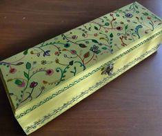 an ornately decorated box sitting on top of a wooden table