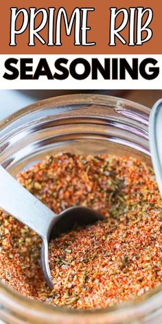 a glass jar filled with seasoning next to a metal spoon on top of it