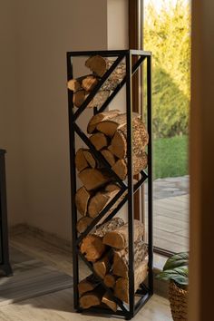 a stack of logs sitting in front of a window