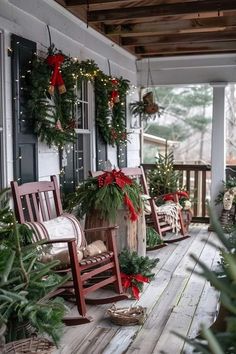 a porch decorated for christmas with rocking chairs and wreaths