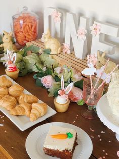 a table topped with cakes and desserts on top of white plates covered in frosting