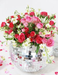 a disco ball vase filled with pink and white flowers