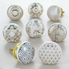 six different types of knobs on a white surface with gold accents and designs painted on them