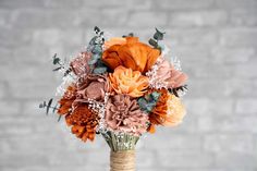 a bouquet of flowers in a vase sitting on a table next to a brick wall