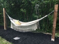 a white hammock sitting in the middle of a yard with black mulch