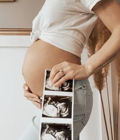 a pregnant woman holding an x - ray with her stomach in front of her belly