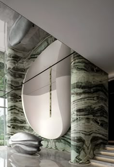 an artisticly designed staircase in the middle of a room with marble walls and flooring