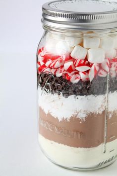 a jar filled with candy canes and marshmallows