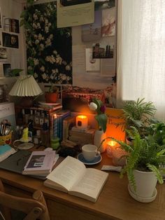 the desk is cluttered with books and plants