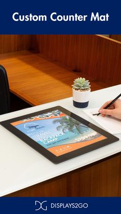 a person sitting at a desk writing on a tablet