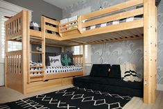 a bunk bed with a futon underneath it and a black couch in the middle