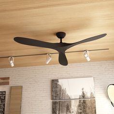 a ceiling fan mounted to the side of a brick wall in a room with white bricks