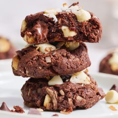 three cookies stacked on top of each other with white chocolate and chopped walnuts in the middle