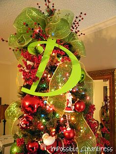 a christmas tree decorated with green and red balls, ornaments, and a musical note