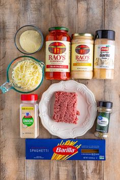 ingredients to make pasta laid out on a wooden table including meat, cheese and seasonings