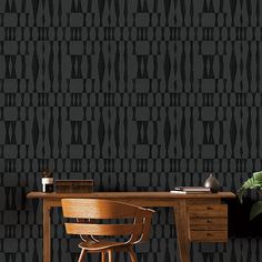 a desk and chair in front of a black wallpaper with geometric shapes on it