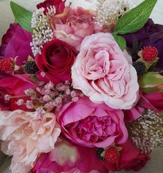 a bouquet of pink and red flowers sitting on top of a couch