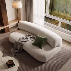 a living room filled with furniture and a large window overlooking the trees outside in front of it