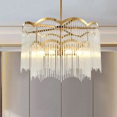 a chandelier hanging from the ceiling in a room with white walls and flooring