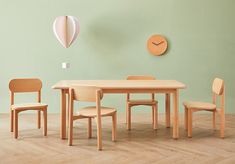 a wooden table with chairs and a clock on the wall