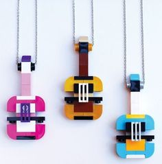 three necklaces made out of lego blocks are hanging on chains, one is colorful and the other is black