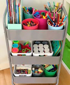 a metal cart filled with lots of different colored pencils and other arts and crafts supplies