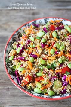 a bowl filled with rice and vegetables on top of a wooden table