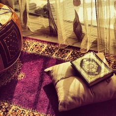 an old book sitting on top of a couch next to a lamp and rugs