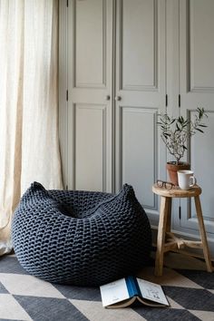 a bean bag chair sitting on top of a checkered floor next to a book