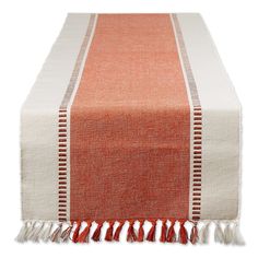 an orange and white table runner with tassels