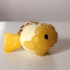 a keychain shaped like a fish with a piece of fruit attached to it