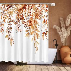 a bath room with a tub and a shower curtain covered in autumn leaves on it