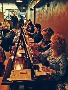 people sitting at long tables with wine glasses