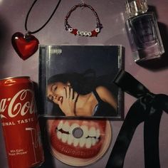 an assortment of items including a coca cola can, cd and necklace