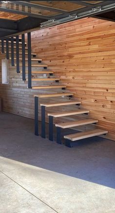 an empty room with wooden walls and stairs