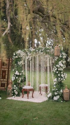 an outdoor ceremony setup with white flowers and greenery