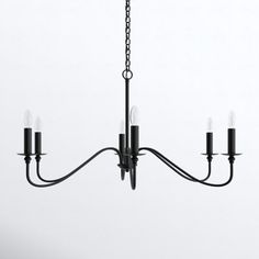 a black chandelier with five candles hanging from it