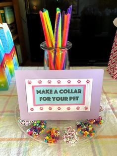 there is a sign that says make a collar for your pet on the table next to some candy