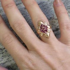 This vintage statement ring is made of 18K yellow gold. Set in the center are nine round and oval shaped rubies in various shades of pink and red. These rubies create a floral motif with four round diamonds at each corner point. The scalloped edge of the center ring with the thin band gives this ring a delicate touch.Metal: 18K Yellow GoldRubies: .83 CTW ApproximateDiamonds: .04 CTWWidth: 22.5 MMSize: 5.75 If you have any questions about this product or if we can help you with any of our other p Vintage Ruby Wedding Rings, Art Deco Ruby Engagement Ring, Unique Jewelry Vintage, Ruby Wedding Rings, Unusual Engagement Rings, Ruby And Diamond Ring, Ruby Diamond Rings, Ruby Engagement Ring, Rings Jewelry Fashion