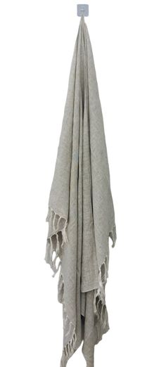 a white towel hanging on a hook with fringes and tassels around it