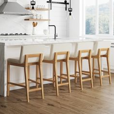 four chairs are lined up in front of the kitchen counter and bar with open shelves