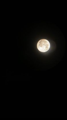 the moon is shining brightly in the dark sky