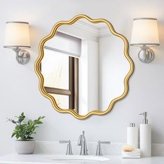 a bathroom sink with a mirror and two lights on the wall next to each other