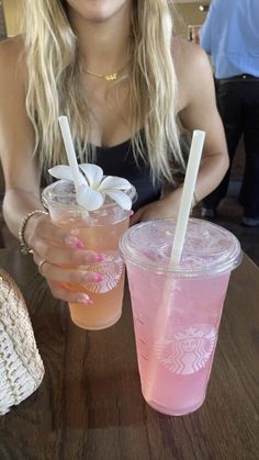 a woman sitting at a table with two drinks