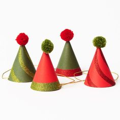 four party hats with pom - poms on them