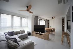 a living room filled with furniture and a flat screen tv on top of a wooden stand